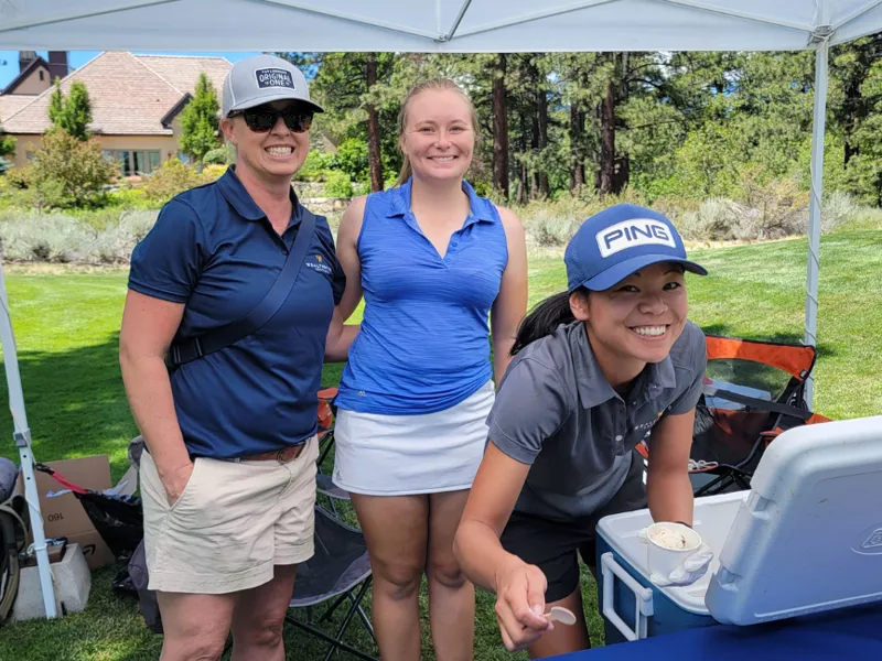 three women at golf outing tent